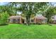 Charming one-story home with a beautiful front lawn, mature trees and brick exterior at 6605 Grosvenor Pl, Indianapolis, IN 46220