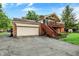 Two-story home features brick exterior, garage, and a wooden deck accessible by stairs on the side of the house at 6605 Grosvenor Pl, Indianapolis, IN 46220