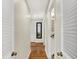 Hallway with wood flooring, white trim, and view to the bathroom at 6605 Grosvenor Pl, Indianapolis, IN 46220