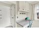 Kitchen detail with white cabinets, grey countertop, blue chair, and window at 6605 Grosvenor Pl, Indianapolis, IN 46220