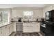 Well-lit kitchen with white cabinetry, stainless steel appliances, and ample counter space at 6605 Grosvenor Pl, Indianapolis, IN 46220