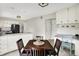Open concept kitchen featuring stainless steel appliances, white cabinetry, and a breakfast nook at 6605 Grosvenor Pl, Indianapolis, IN 46220