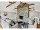 Comfortable living room with a stone fireplace, neutral furnishings, and wood accents on the vaulted ceiling at 6605 Grosvenor Pl, Indianapolis, IN 46220
