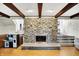 Spacious living room with a stone fireplace, hardwood floors, and beamed ceilings at 6605 Grosvenor Pl, Indianapolis, IN 46220