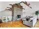 Inviting living room featuring a stone fireplace, hardwood floors, and vaulted ceilings with exposed wood beams at 6605 Grosvenor Pl, Indianapolis, IN 46220