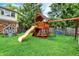 Backyard features a wooden playset with a slide, swings, and playhouse, providing hours of fun for children at 6605 Grosvenor Pl, Indianapolis, IN 46220
