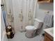 Modest bathroom featuring a toilet, vanity, floral shower curtain and decor at 705 S 450 E, Franklin, IN 46131