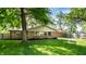 Well-maintained home exterior with brick facade, green lawn, and mature trees providing ample shade at 7110 N Layman Ave, Indianapolis, IN 46250