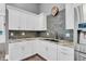 Stylish kitchen with stone backsplash, white cabinets, and stainless steel appliances at 720 Willow Pointe North Dr, Plainfield, IN 46168