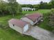 Aerial view featuring a home with a garage and a well-maintained driveway, surrounded by green lawns and trees at 7214 W Reformatory Rd, Fortville, IN 46040