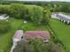 Aerial view showcasing the home's setting amidst mature trees and lush greenery, with a garage nearby at 7214 W Reformatory Rd, Fortville, IN 46040