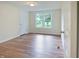 Empty bedroom with wood-look flooring, neutral walls, and a double window overlooking the scenery at 7214 W Reformatory Rd, Fortville, IN 46040
