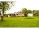 Cozy home featuring a sunroom addition and a detached garage, all surrounded by a lush green lawn at 7214 W Reformatory Rd, Fortville, IN 46040