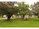 Residential house with a well-kept front yard and mature shade trees, showcasing its curb appeal at 7214 W Reformatory Rd, Fortville, IN 46040