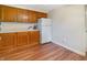 Kitchen with white appliances, wood cabinets, hardwood floors, and access to another room at 7214 W Reformatory Rd, Fortville, IN 46040