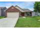 Charming single-story home featuring a brick facade, attached garage, and well-maintained lawn at 7238 Moultrie Dr, Indianapolis, IN 46217