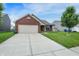 Lovely single-story house with a brick front, attached garage, and green lawn at 7238 Moultrie Dr, Indianapolis, IN 46217