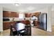 Kitchen featuring wooden cabinets, stainless steel appliances, and an adjacent dining area at 7238 Moultrie Dr, Indianapolis, IN 46217