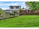 Expansive backyard featuring a charming two-story home, landscaped garden beds, and a spacious deck with scenic views at 7255 Haverhill Ct, Indianapolis, IN 46250