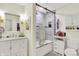 Bright white bathroom featuring marble tile, modern fixtures, and glass shower doors at 7255 Haverhill Ct, Indianapolis, IN 46250