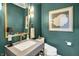 Stylish powder room featuring a concrete sink, a gold mirror, and moody green walls at 7255 Haverhill Ct, Indianapolis, IN 46250