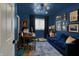 Comfortable home office showcasing a stylish light fixture, blue sofa, and custom blue wall paint at 7255 Haverhill Ct, Indianapolis, IN 46250
