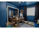 Inviting home office boasts blue walls, natural light, and a cozy workspace with ample storage at 7255 Haverhill Ct, Indianapolis, IN 46250