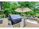 Deck with outdoor kitchen featuring a built-in grill, bar seating, and charming outdoor decor with a beautiful wooded backdrop at 7255 Haverhill Ct, Indianapolis, IN 46250