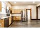 Modern kitchen featuring stainless steel appliances, granite countertops, and natural wood cabinets at 7536 Mccord St, McCordsville, IN 46055