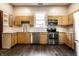 Well-lit kitchen with stainless steel appliances, wooden cabinetry, and laminate floors at 7536 Mccord St, McCordsville, IN 46055