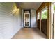 Enclosed front porch featuring a wood deck, sidelight windows and a white storm door at 7536 Mccord St, McCordsville, IN 46055