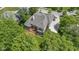 High angle aerial shot of the house, showcasing the deck, backyard, driveway, and tree lined street at 7744 Preservation Dr, Indianapolis, IN 46278