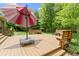 Backyard wooden deck with bench seating and a large patio umbrella for shade at 7744 Preservation Dr, Indianapolis, IN 46278
