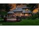 Backyard deck with multiple levels, comfortable seating, and lush landscaping at dusk at 7744 Preservation Dr, Indianapolis, IN 46278