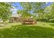 Spacious backyard with mature trees, a large deck, and a fire pit for outdoor enjoyment at 7744 Preservation Dr, Indianapolis, IN 46278
