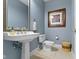 Charming powder room with pedestal sink, framed mirror, and decorative accents at 7744 Preservation Dr, Indianapolis, IN 46278