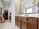 Bathroom with a double vanity, walk-in closet, tiled floors, and a large mirror at 7744 Preservation Dr, Indianapolis, IN 46278