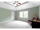 Spacious bedroom with tray ceilings, neutral carpet, and comfortable seating area at 7744 Preservation Dr, Indianapolis, IN 46278