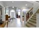 Grand foyer with tiled floors, arched doorways, piano, and staircase at 7744 Preservation Dr, Indianapolis, IN 46278
