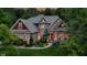 An eye-level front exterior view showcasing the red front door and meticulously landscaped yard at 7744 Preservation Dr, Indianapolis, IN 46278