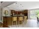 Spacious kitchen features dark wood cabinetry, center island with barstool seating, and tile flooring at 7744 Preservation Dr, Indianapolis, IN 46278