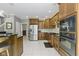 Kitchen featuring stainless steel appliances, dark wood cabinetry, and adjacent doorway at 7744 Preservation Dr, Indianapolis, IN 46278