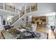 Bright, open-concept living room featuring hardwood floors, comfortable seating, and views into kitchen at 7744 Preservation Dr, Indianapolis, IN 46278