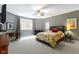 Spacious bedroom with ceiling fan, good natural light, and an attached desk and work area at 7744 Preservation Dr, Indianapolis, IN 46278