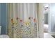 Shower curtain with floral design in blue bathroom at 7744 Preservation Dr, Indianapolis, IN 46278