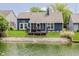 Waterfront backyard featuring a deck, screened porch, and serene lake views at 7838 Chesapeake E Dr, Indianapolis, IN 46236