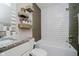 Bathroom featuring granite counters, a tiled tub/shower, and decorative floating shelves at 7838 Chesapeake E Dr, Indianapolis, IN 46236
