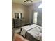 Comfortable bedroom features a dresser with a mirror, a bench, and a window with decorative curtains at 7838 Chesapeake E Dr, Indianapolis, IN 46236