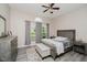 Comfortable bedroom featuring neutral colors, a ceiling fan, and a window with backyard view at 7838 Chesapeake E Dr, Indianapolis, IN 46236