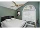 Bedroom featuring sage walls, a ceiling fan, and a large window with backyard view at 7838 Chesapeake E Dr, Indianapolis, IN 46236